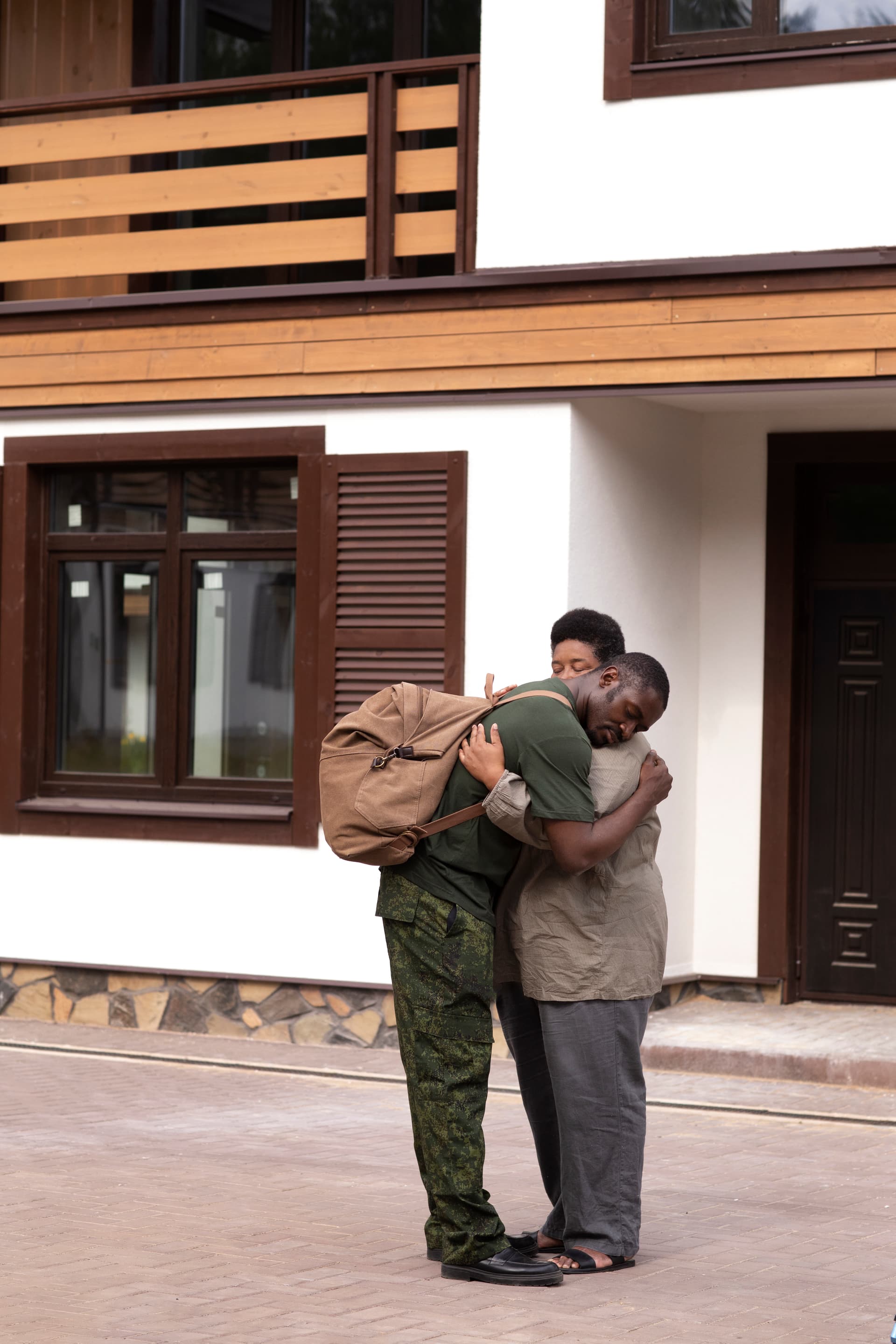 A service member in uniform embracing family during a departure