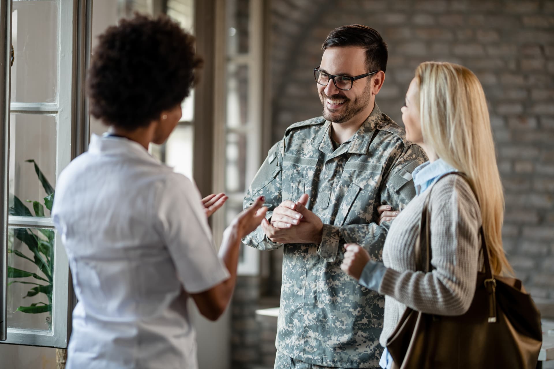A service member and partner speaking with a care professional